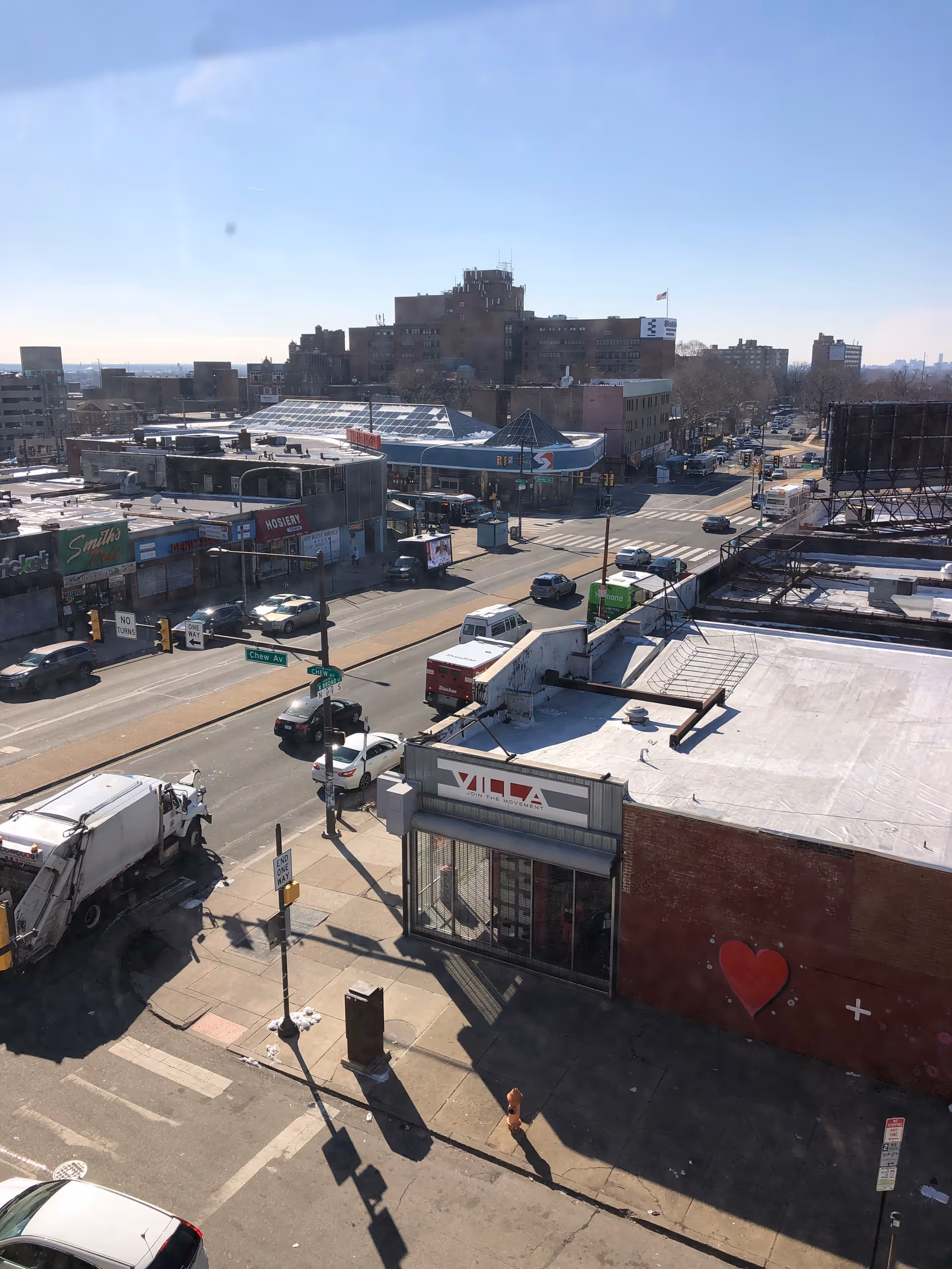 Aerial street view of a busy North Philadelphia neighborhood with storefronts and vehicles.