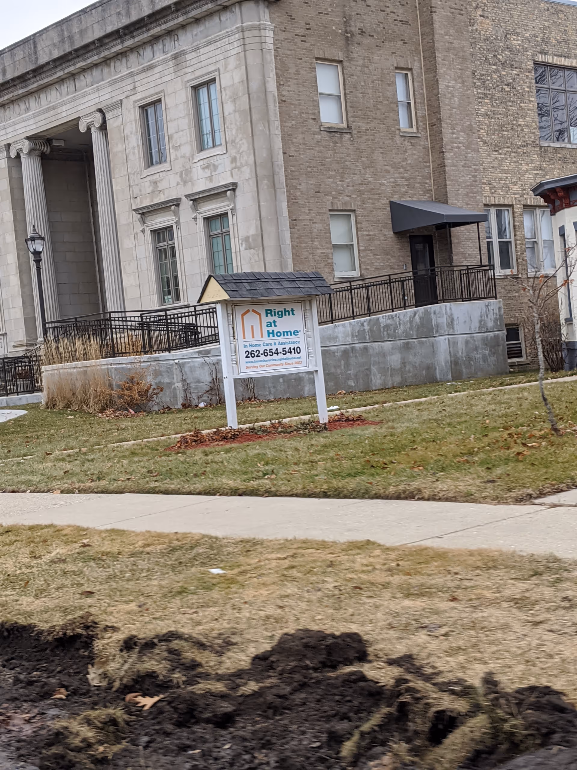 Exterior view of a Right at Home facility with a sign on the lawn.