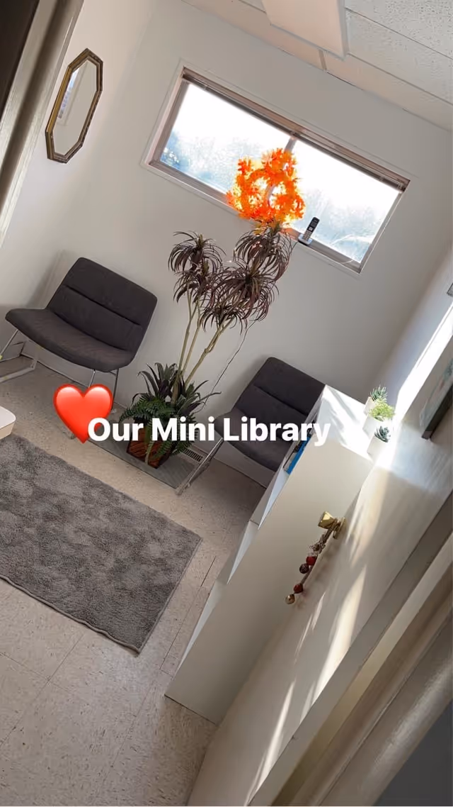 Indoor seating area with two chairs, a tall plant, window, and Our Mini Library text overlay.