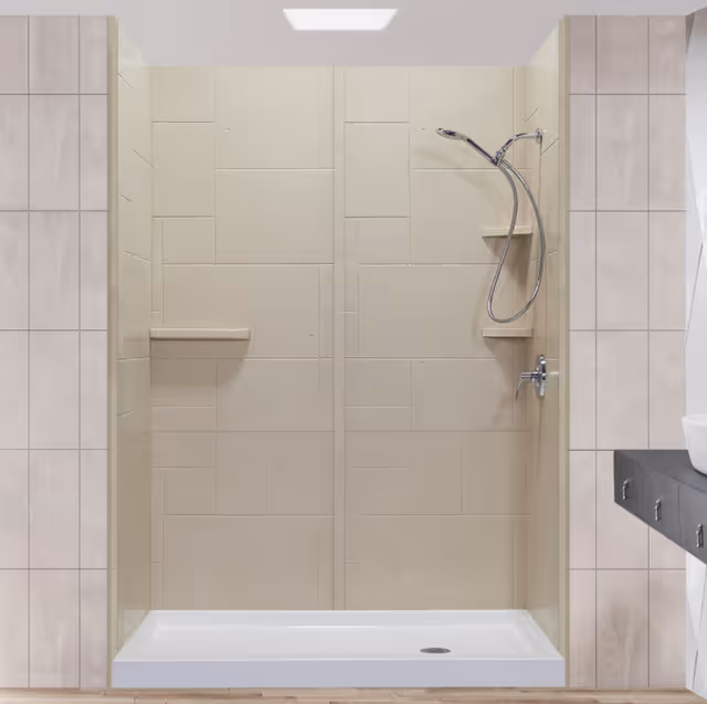 Beige tiled walk-in shower with handheld showerhead and built-in shelves in a bathroom.