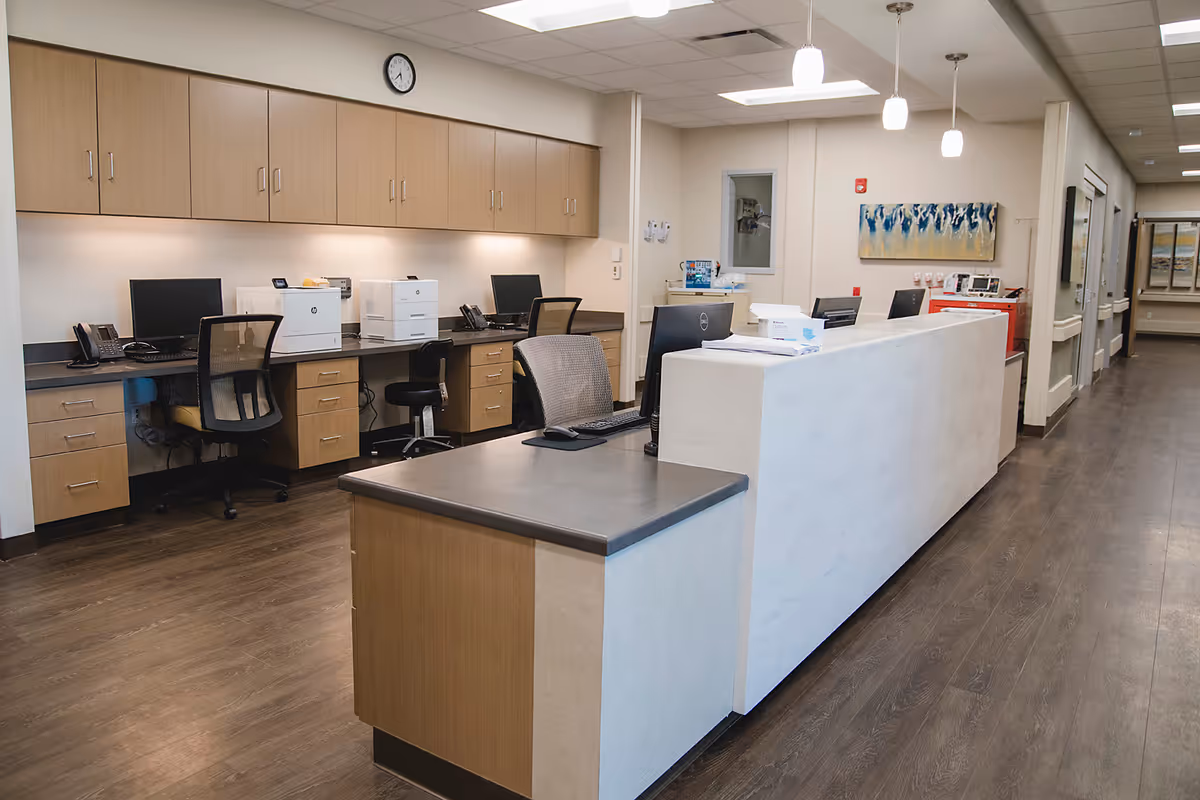 Reception area inside NW Indiana ER & Hospital with a long desk and cabinets.