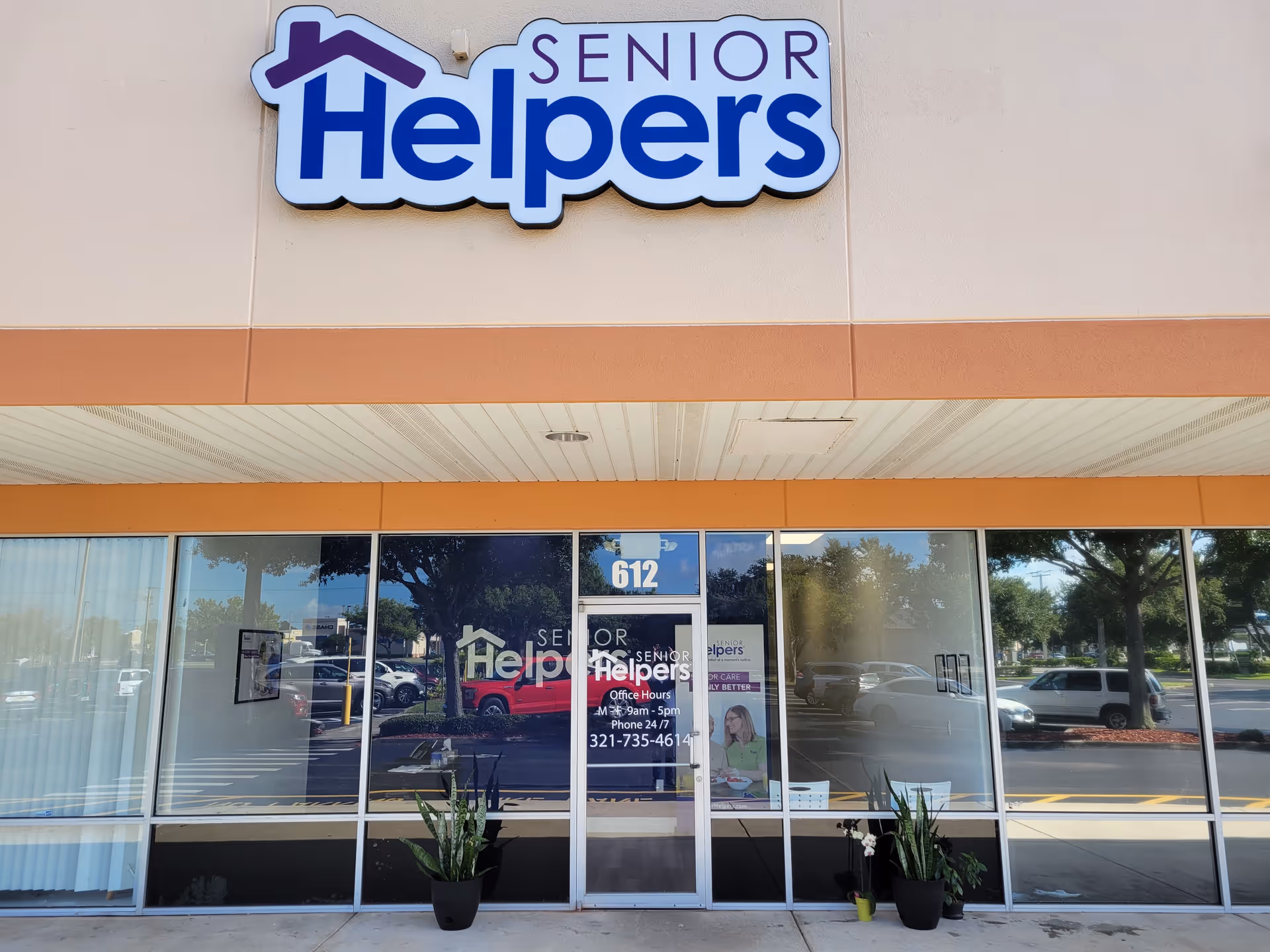 Exterior view of Senior Helpers facility with large sign and glass storefront.