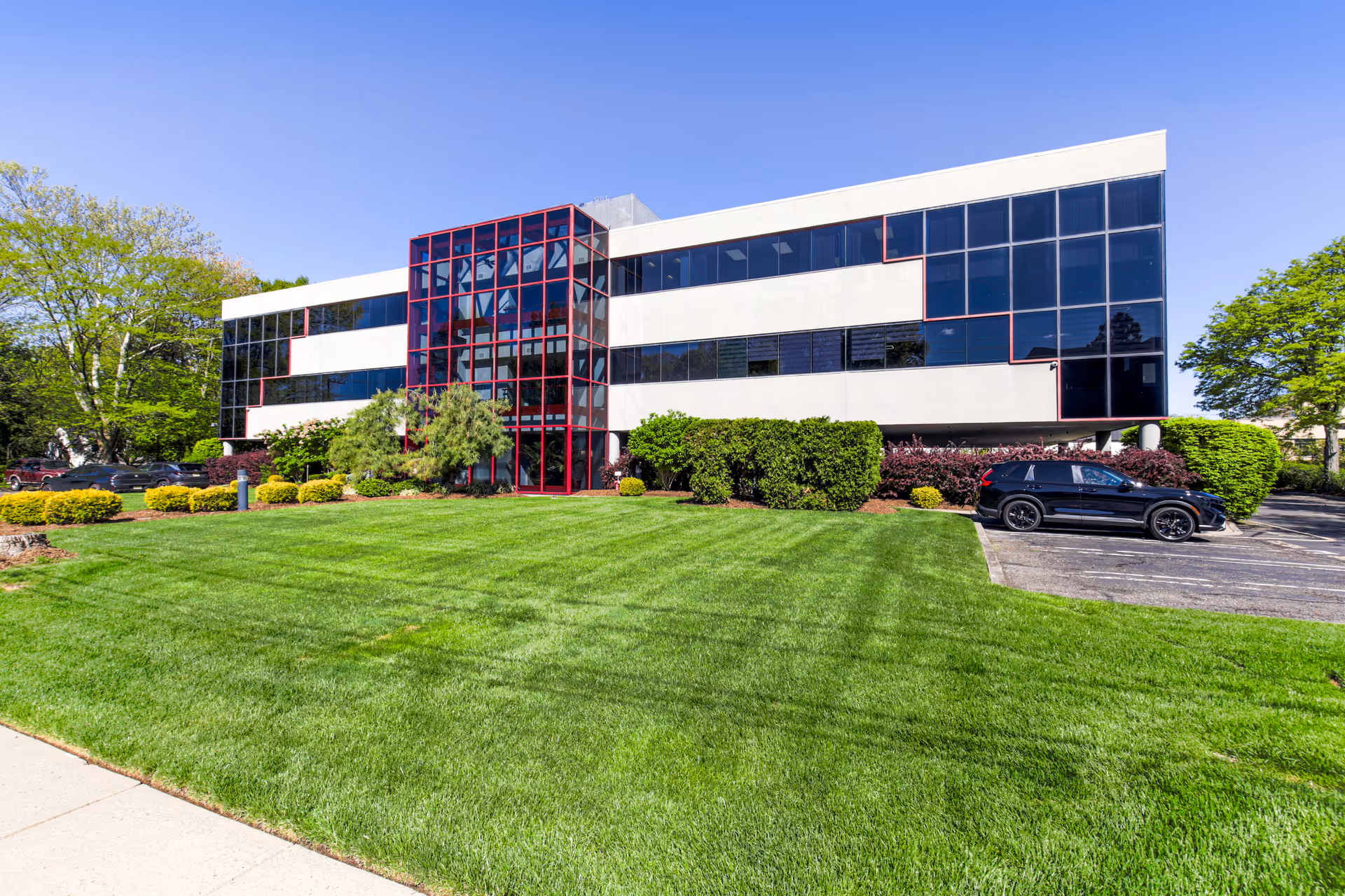 Exterior view of Amada Senior Care building with glass facade and manicured lawn