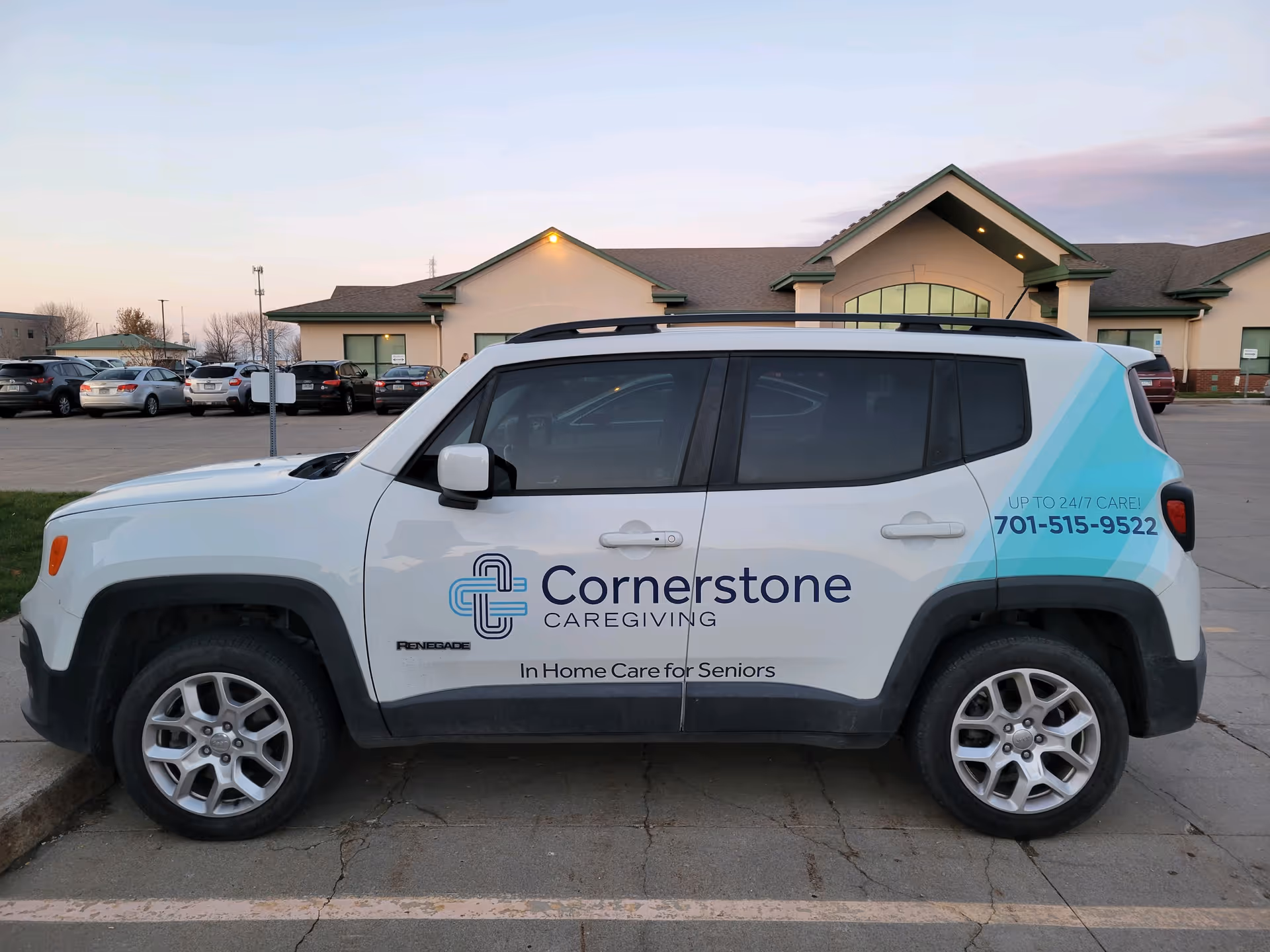 A white Cornerstone Caregiving van parked in front of a beige facility.