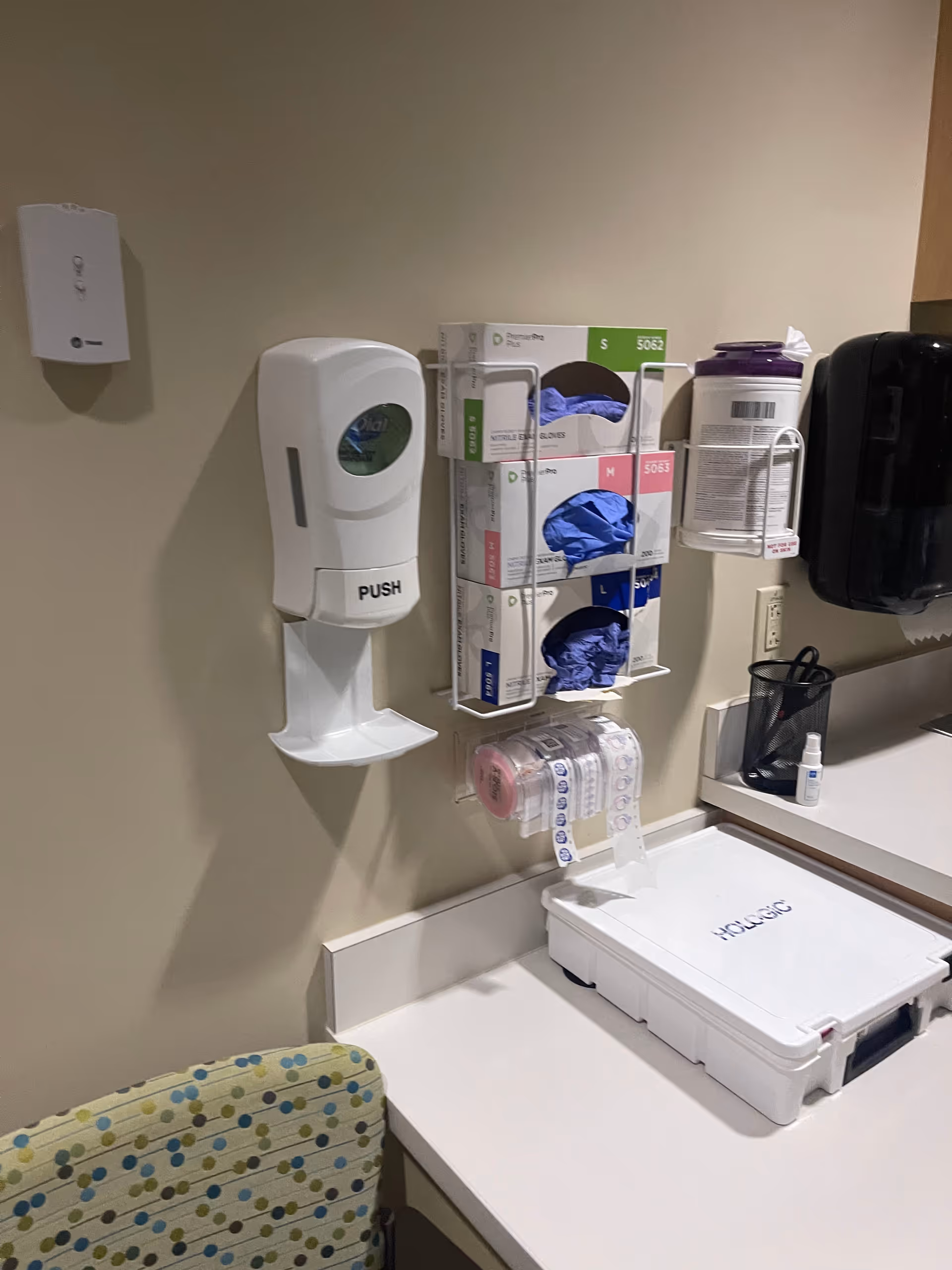Interior medical supply area with sanitizer dispenser, glove rack, and labeled medical kit.