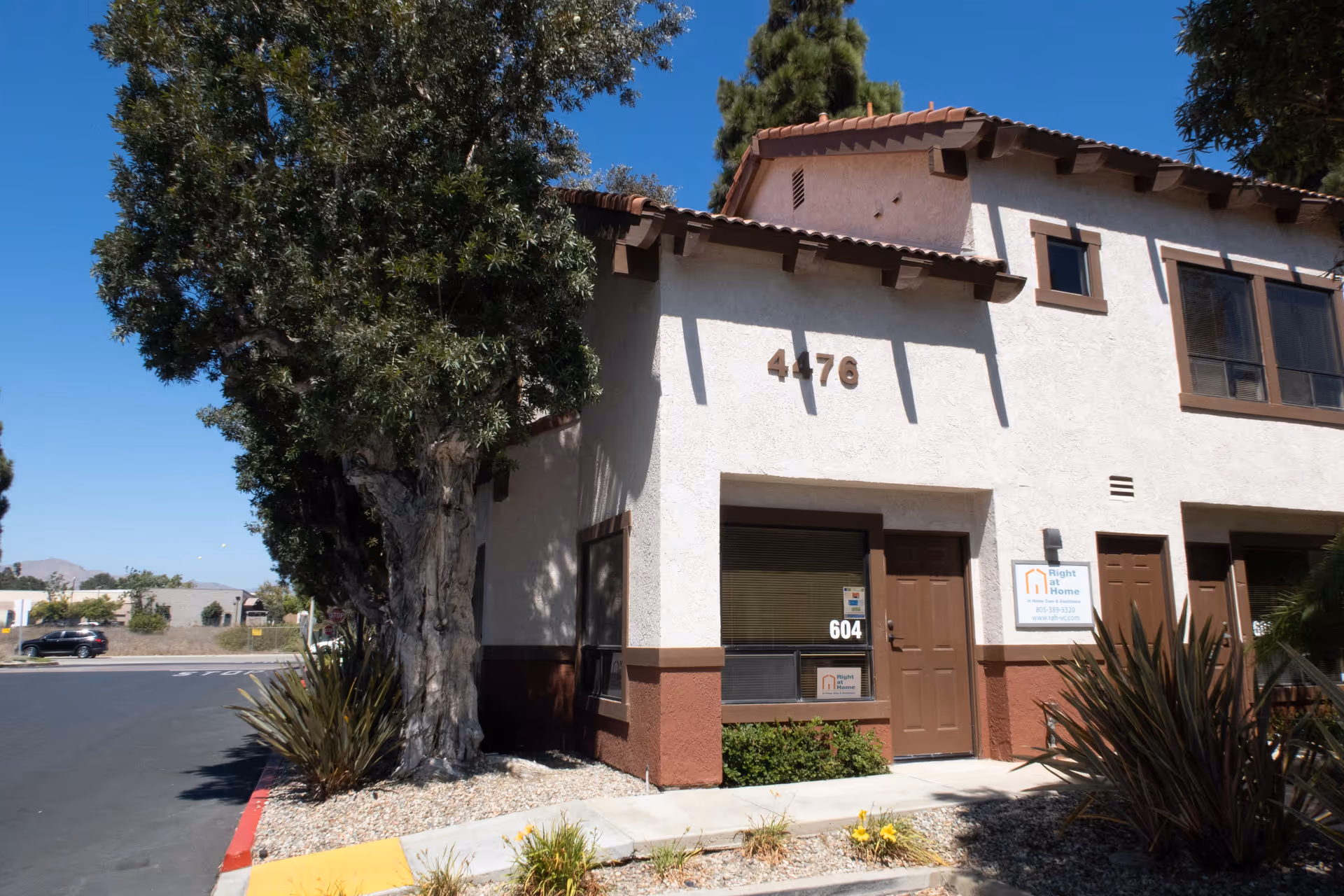 Two-story beige senior living facility with brown trim and a visible entrance sign.