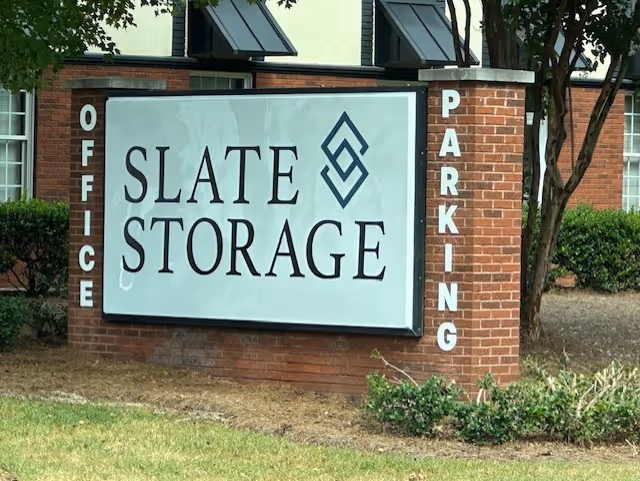 Brick sign reading Slate Storage with vertical OFFICE and PARKING lettering beside the building