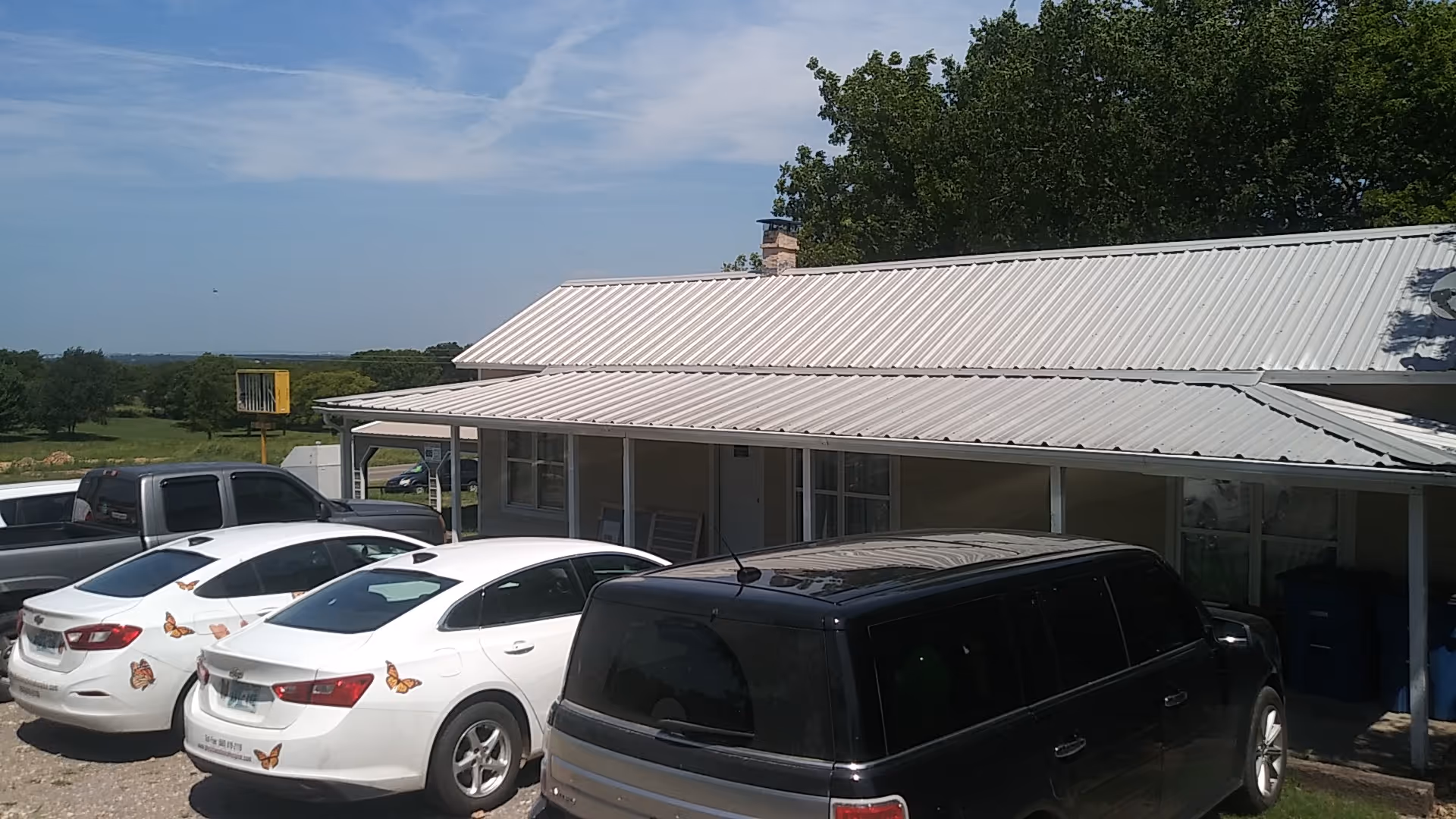 Exterior view of a single-story healthcare facility with a metal roof and parked cars.
