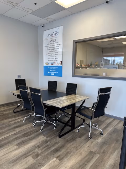 Interior conference room at UrbanCare Home Care with a rectangular table and six rolling black chairs.