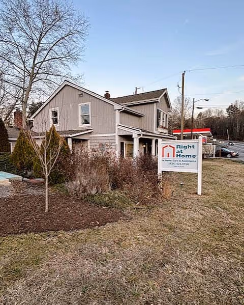 Exterior view of a two-story building with a Right at Home sign in front yard.