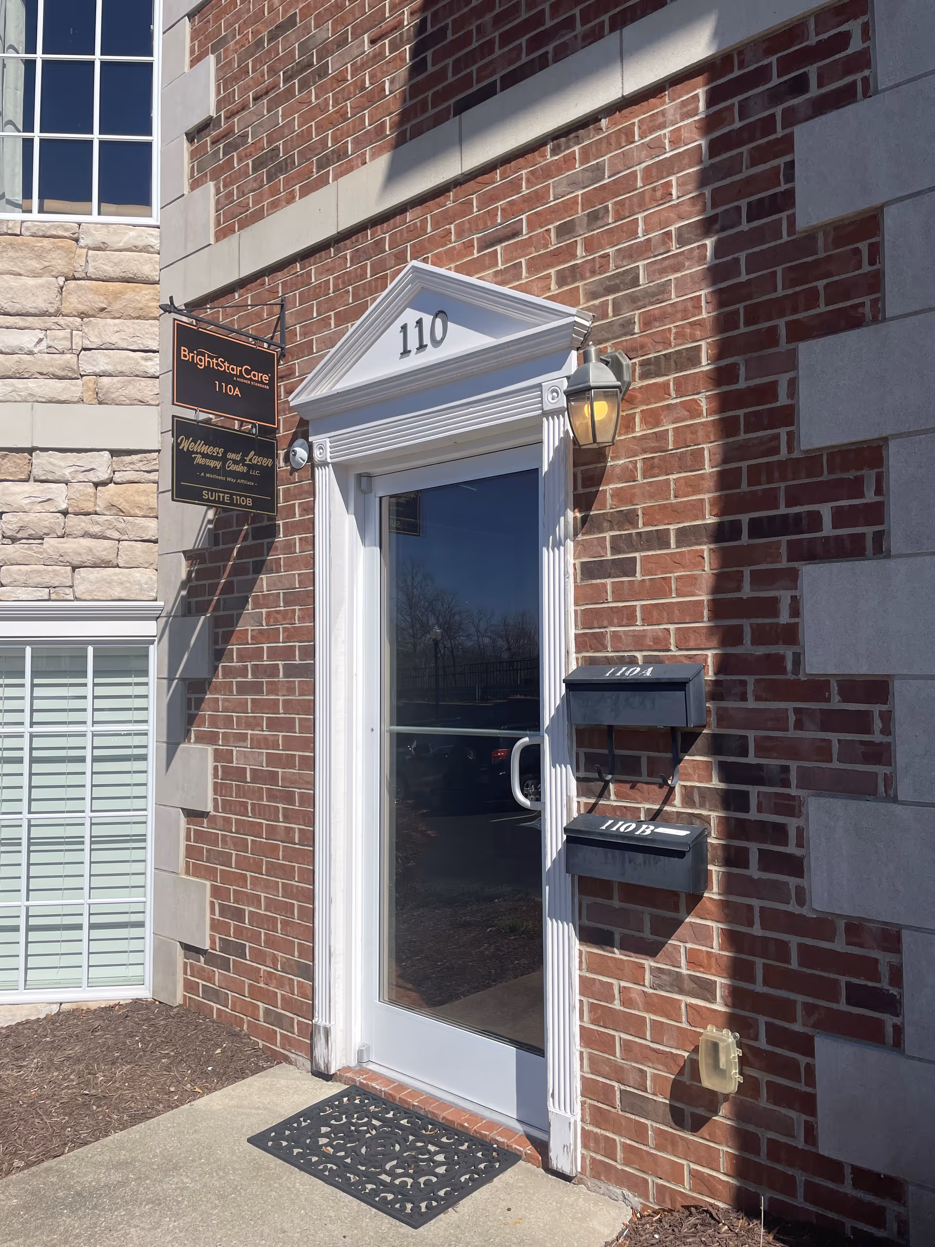 Brick facility entrance with BrightStar Care sign and glass door at 110.