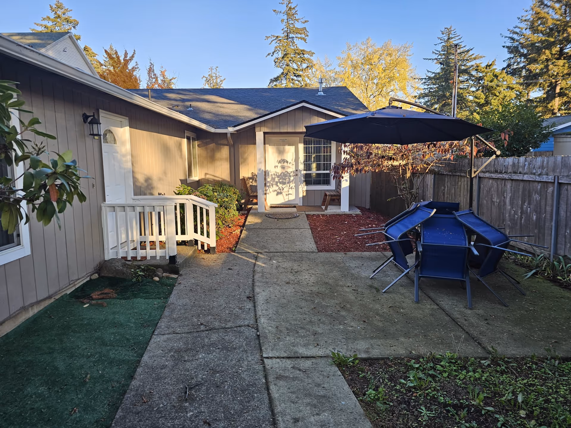 Backyard patio of Destiny Care Home LLC with outdoor table, chairs, and umbrella.