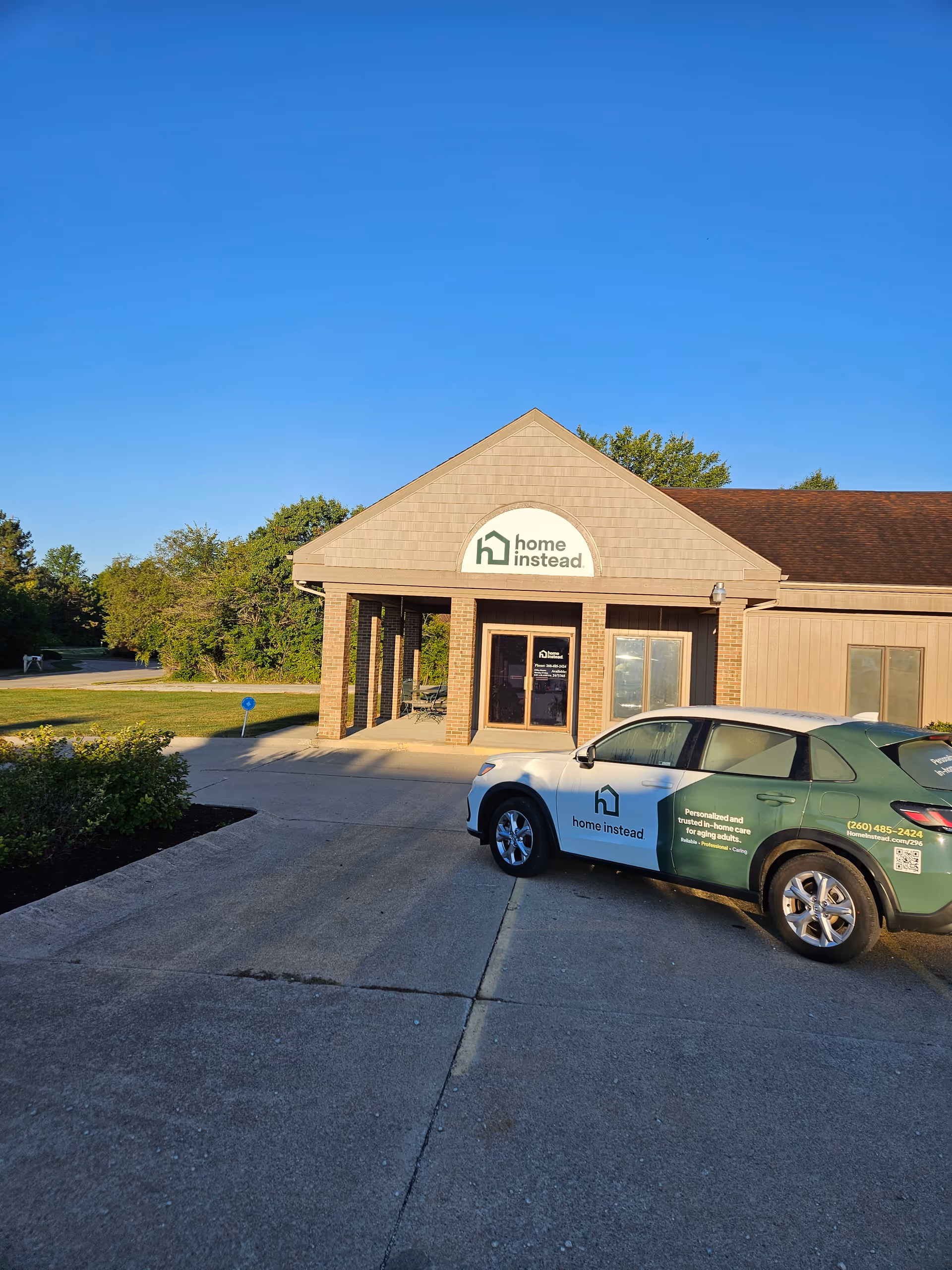 Front view of a Home Instead facility with a parked service car.