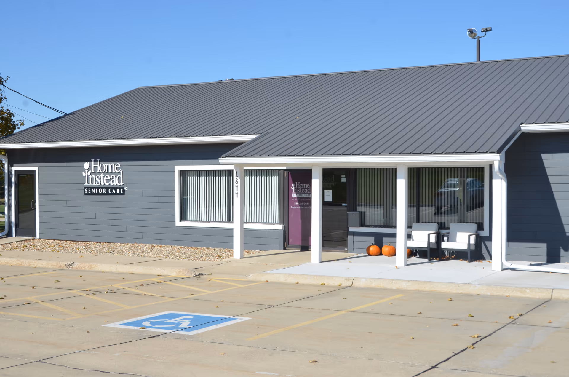 Exterior view of a Home Instead Senior Care building with entrance and porch seating.