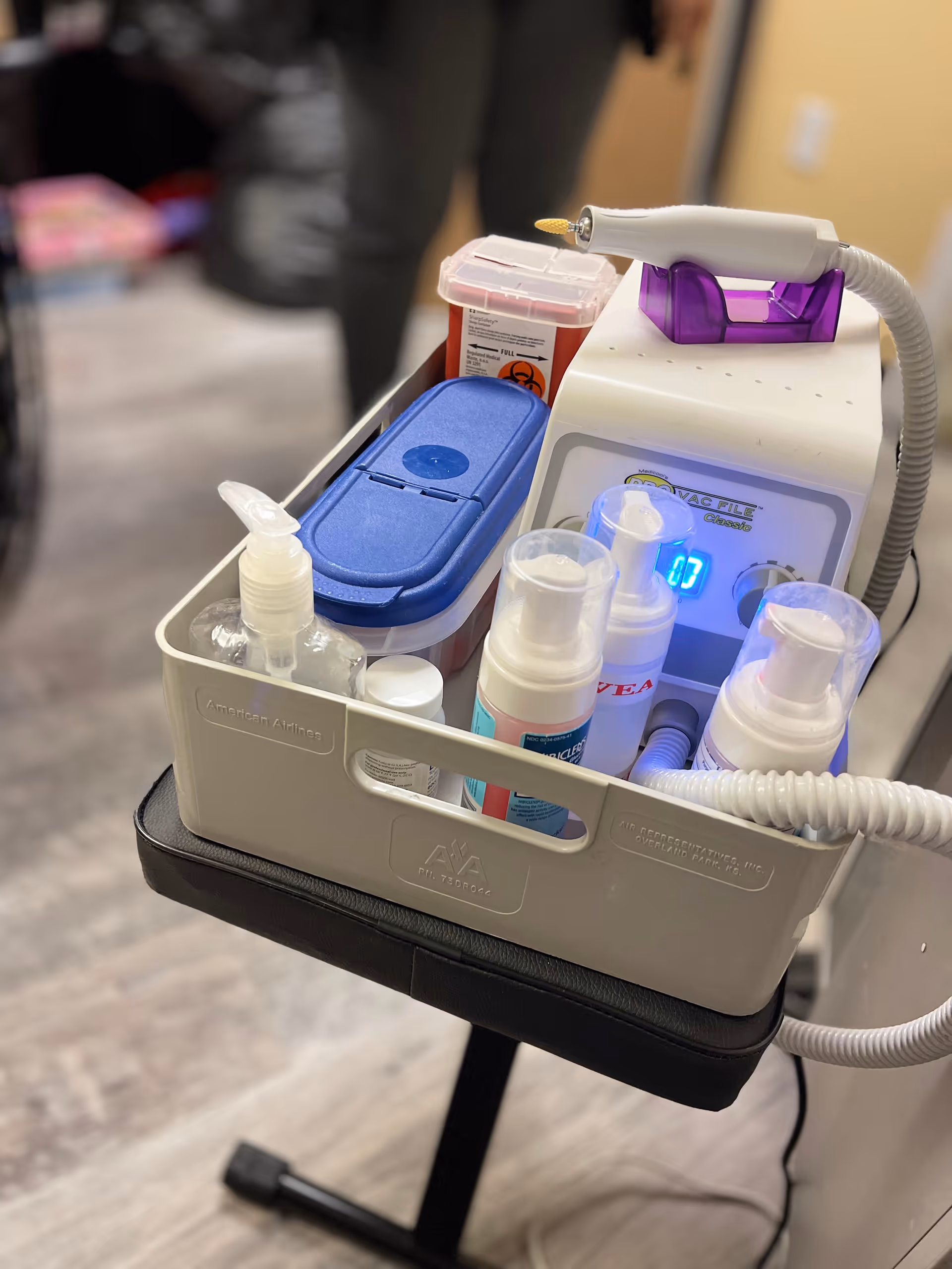 Mobile medical cart with supplies in a podiatry clinic room.