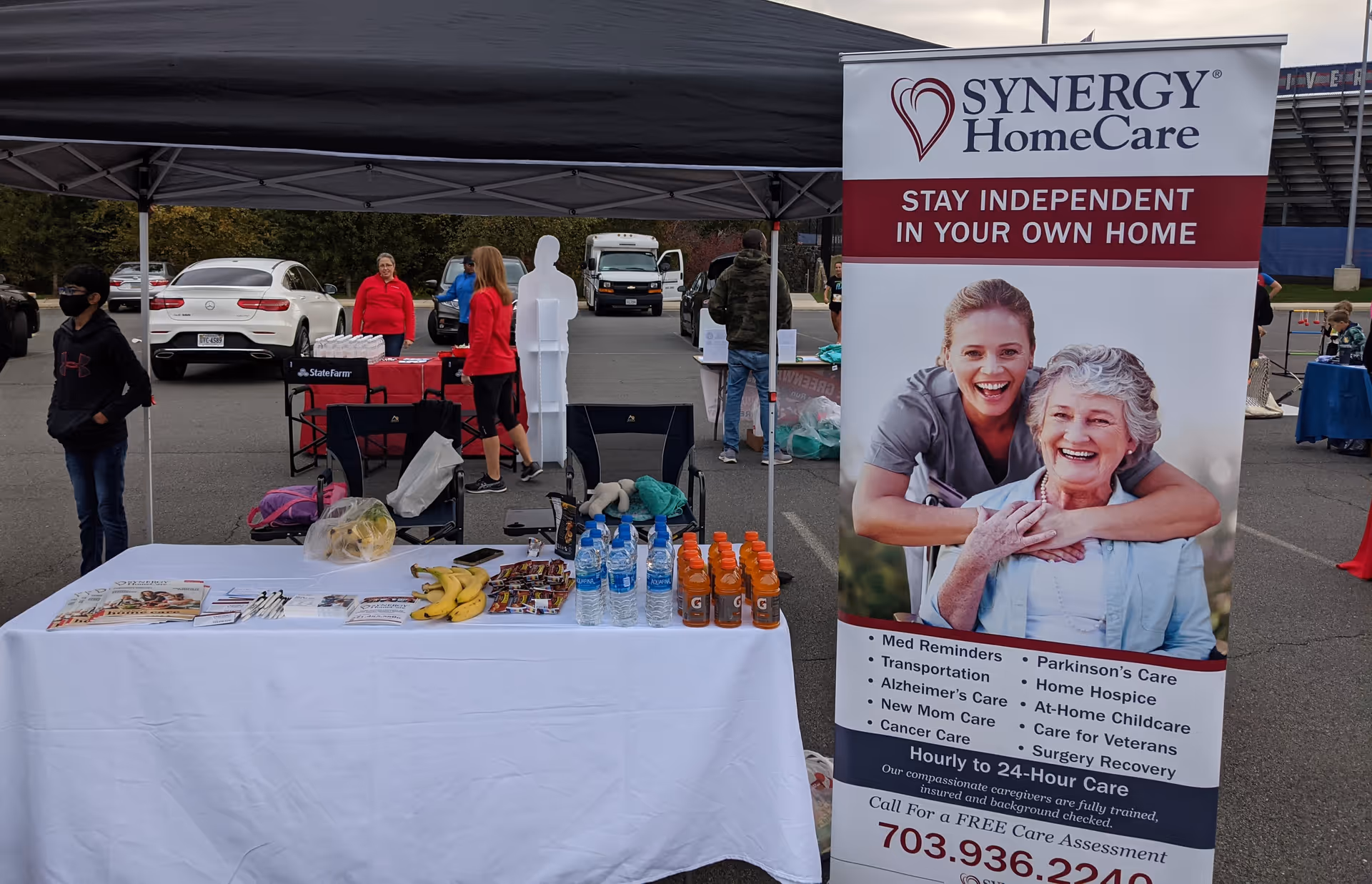 Outdoor Synergy HomeCare booth with banner and table of materials