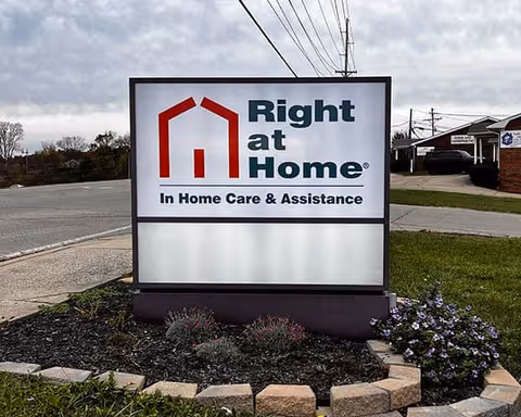 Outdoor sign for Right at Home senior care with landscaping along a road