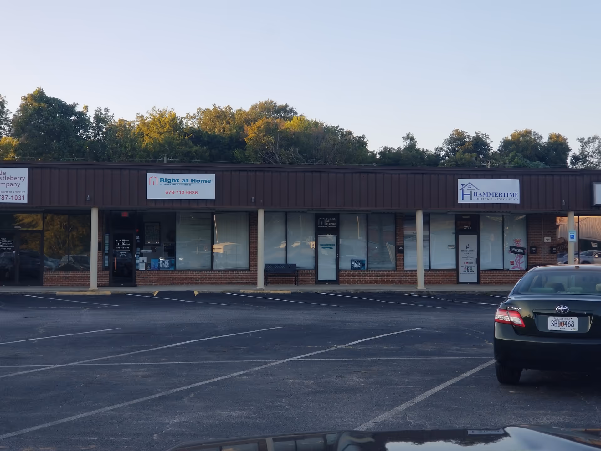 A storefront strip mall exterior showing Right at Home and other businesses in a parking lot.