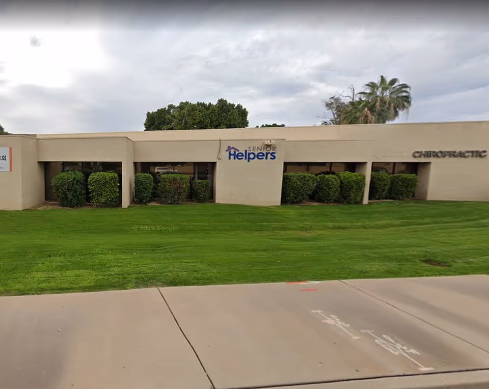 Exterior view of Senior Helpers building with trimmed shrubs and a sign.
