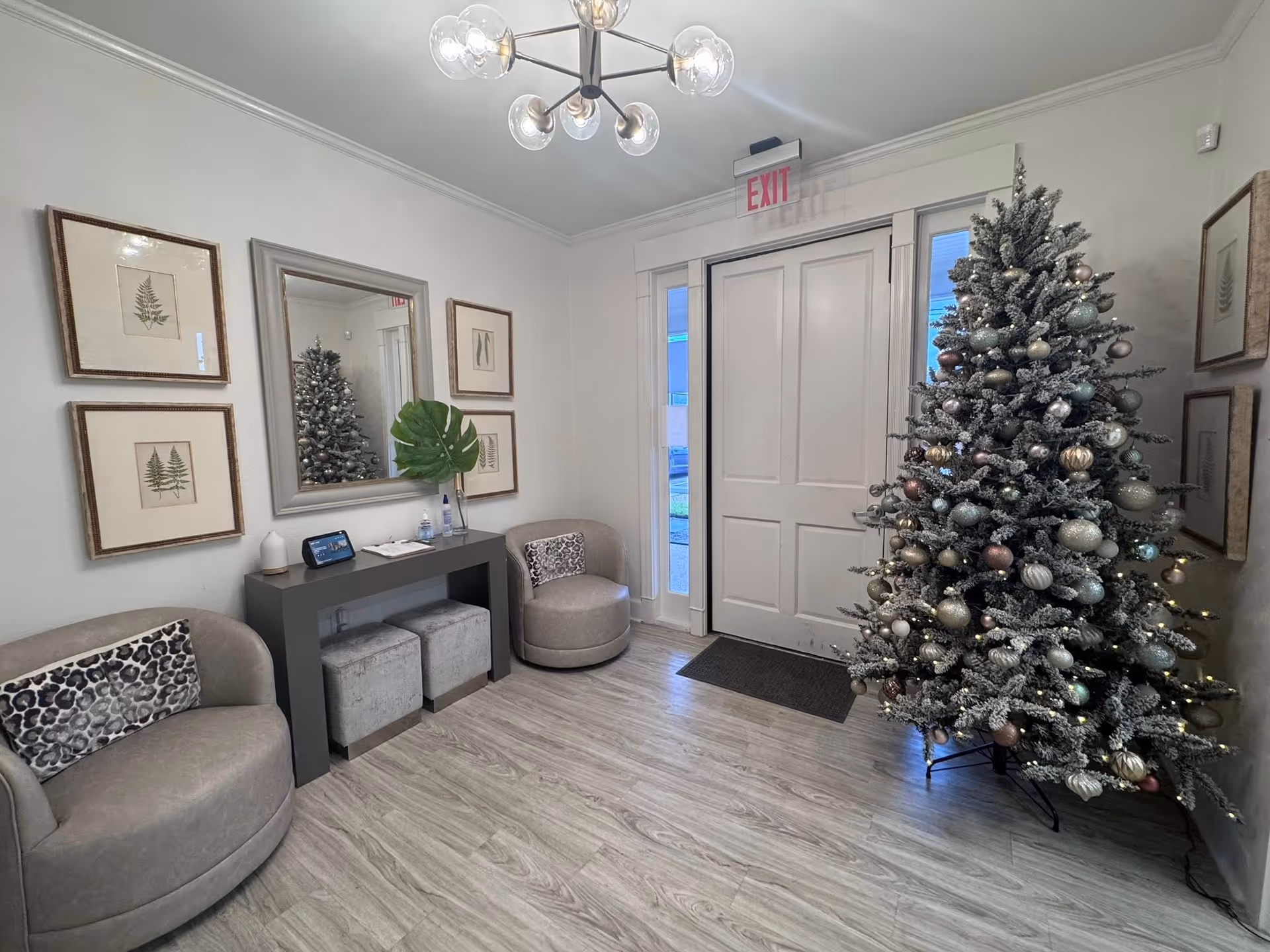 A cozy lobby area with a large Christmas tree and seating near a front door.