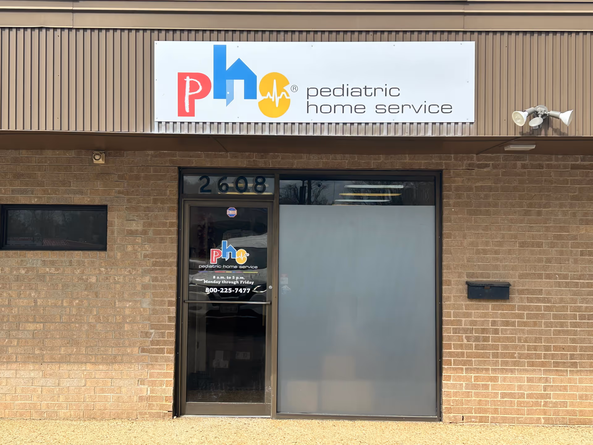 Exterior view of a brick building with a Pediatric Home Service sign above the entrance.
