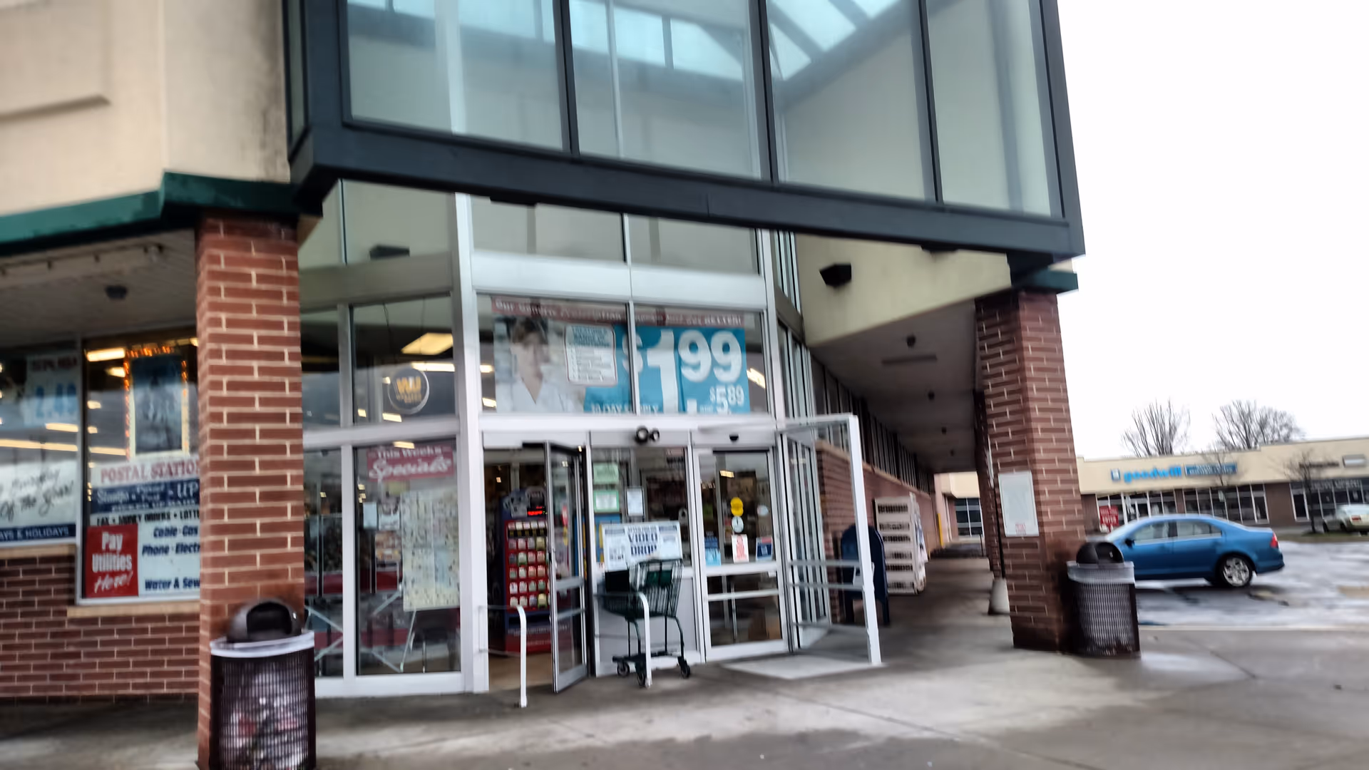 Exterior view of Discount Drug Mart storefront with glass entrance and parking lot.