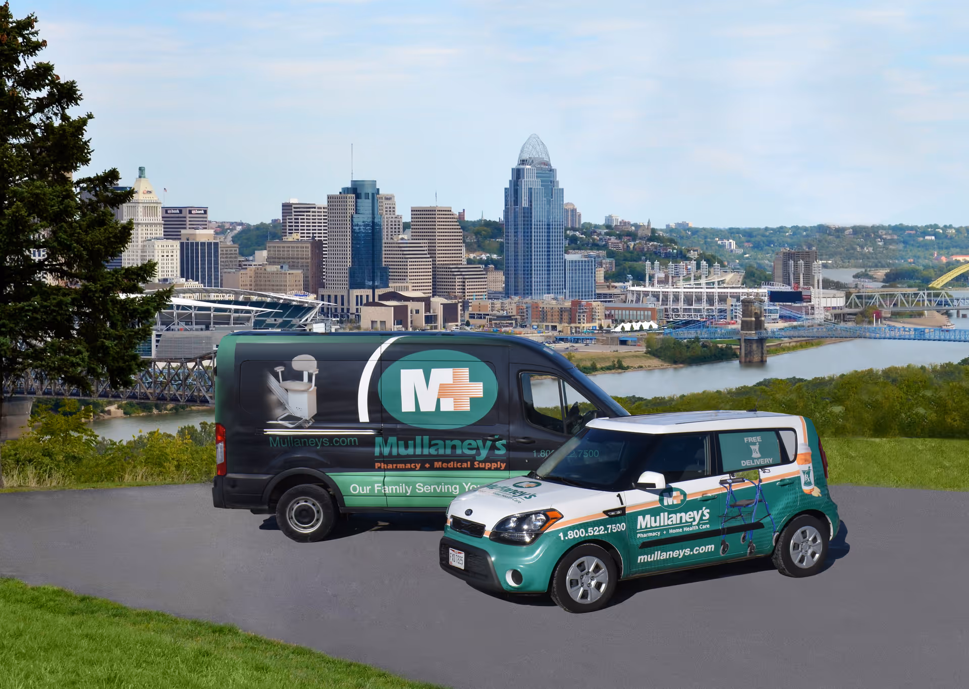 Two Mullaney's branded delivery vehicles parked on a road with skyline in background.