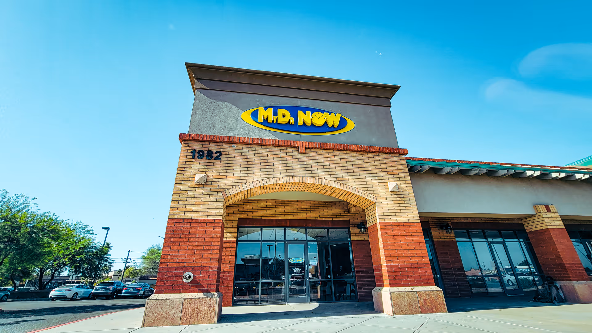 Exterior view of a brick building with glass entrance and a MY DR NOW sign.