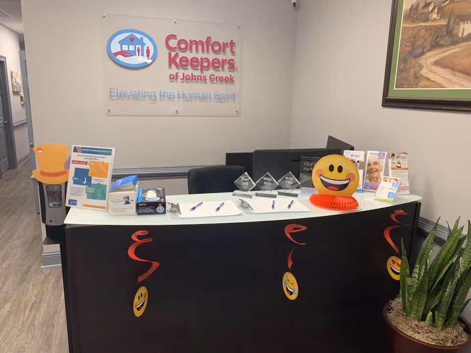 Reception desk at Comfort Keepers with sign, brochures, and a smiling emoji decoration.