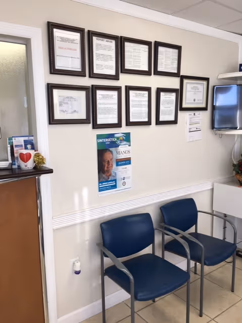 Interior lobby area at St. Francis Community Care with framed certificates and blue waiting chairs.