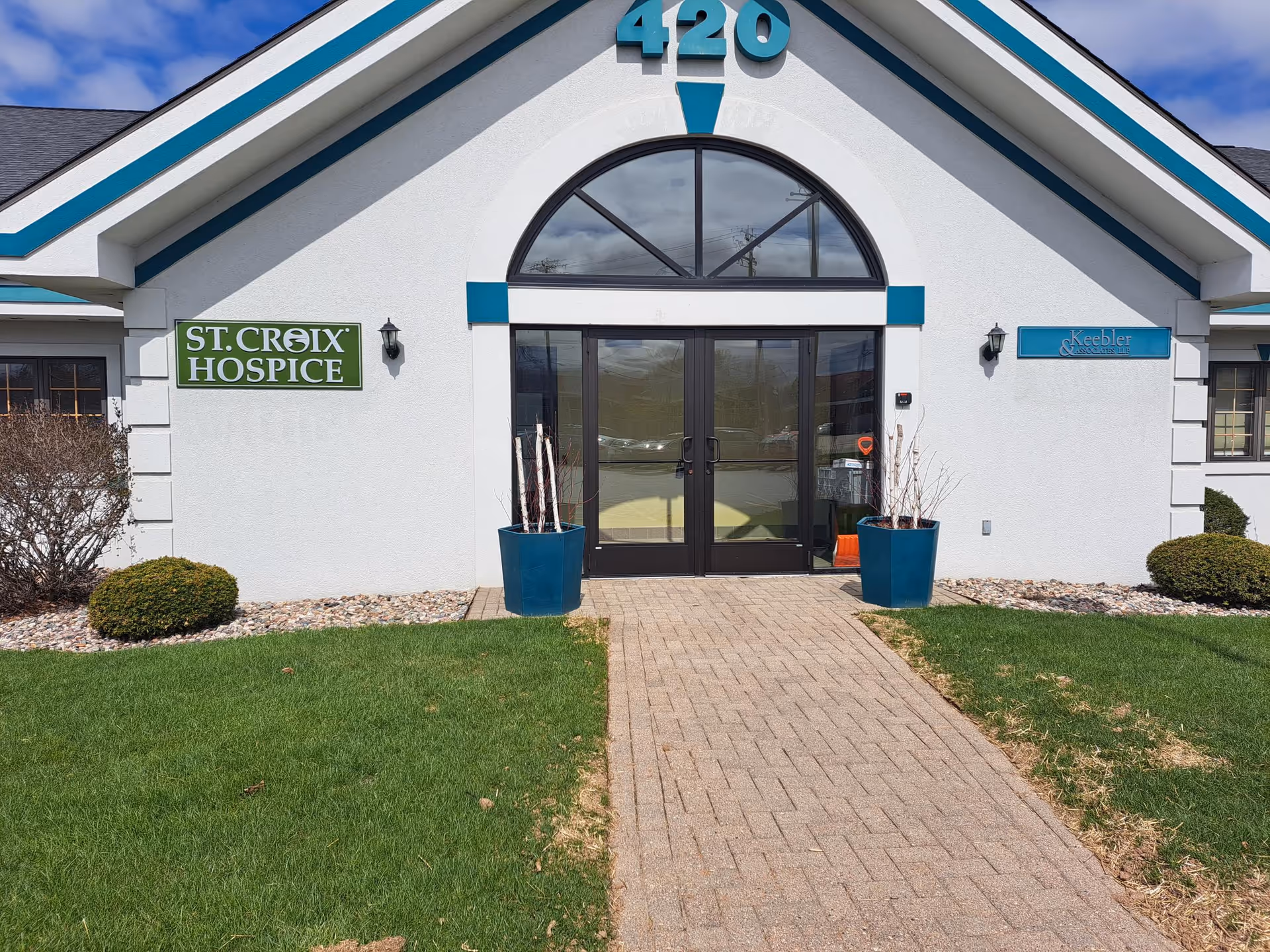 Front view of St. Croix Hospice building with glass doors and turquoise trim