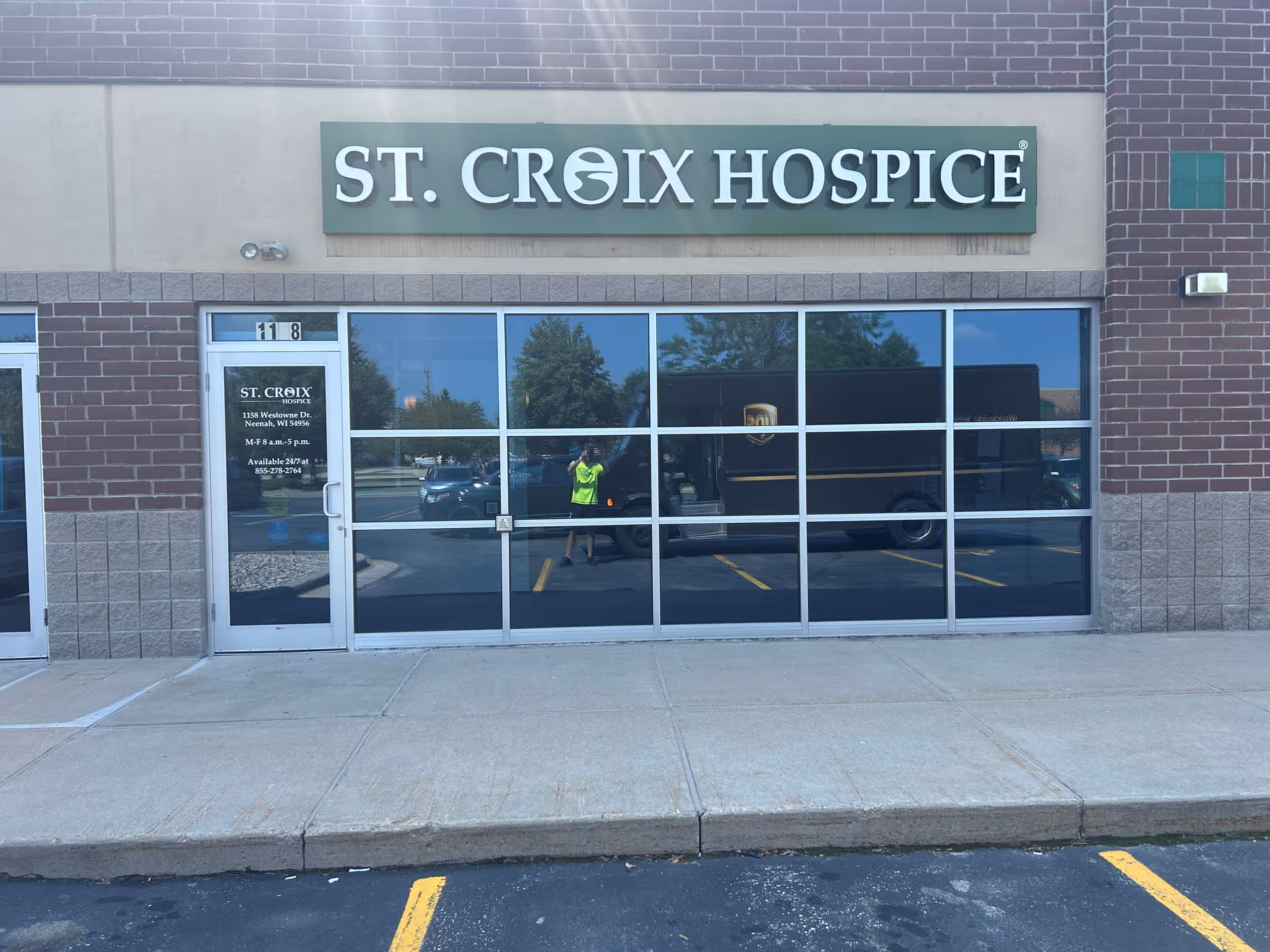Front of St. Croix Hospice building with large glass storefront and sign above.