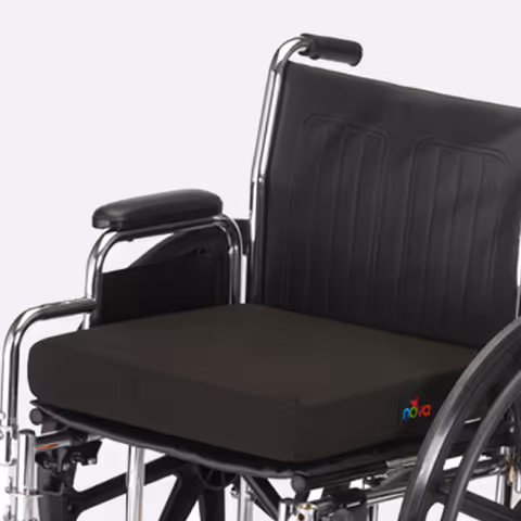 A black cushioned wheelchair with chrome frame indoors.