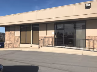 Front view of Enhabit Home Health building with glass doors and ramp.