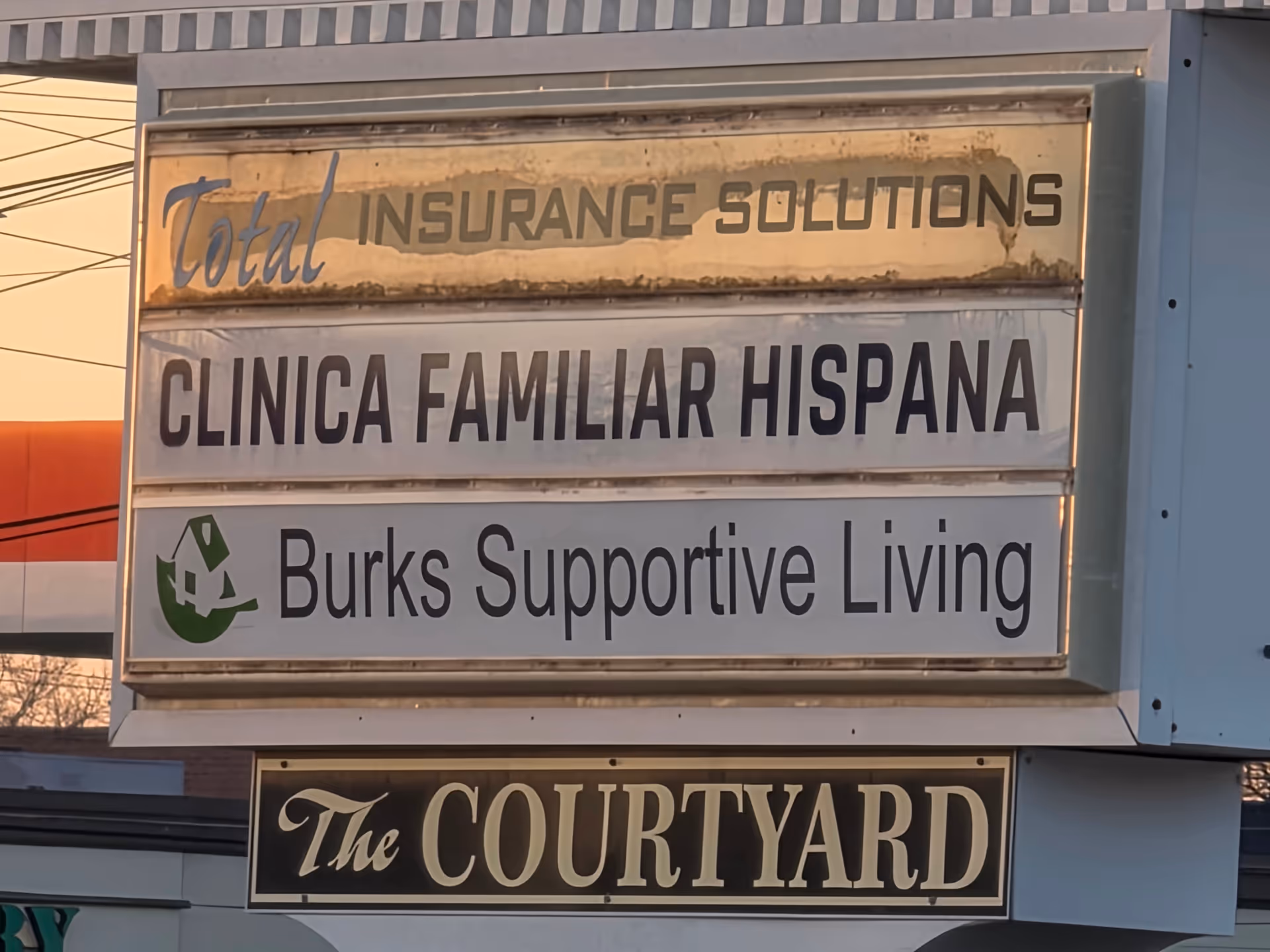 Exterior signboard on a building displays Burks Supportive Living alongside other tenants