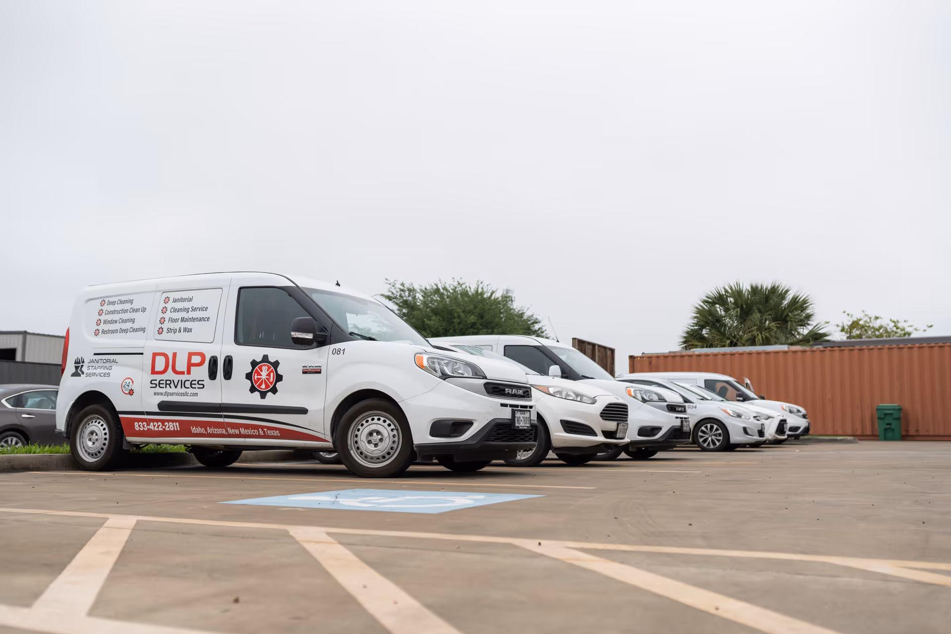 White DLP Services van in a parking lot with other cars