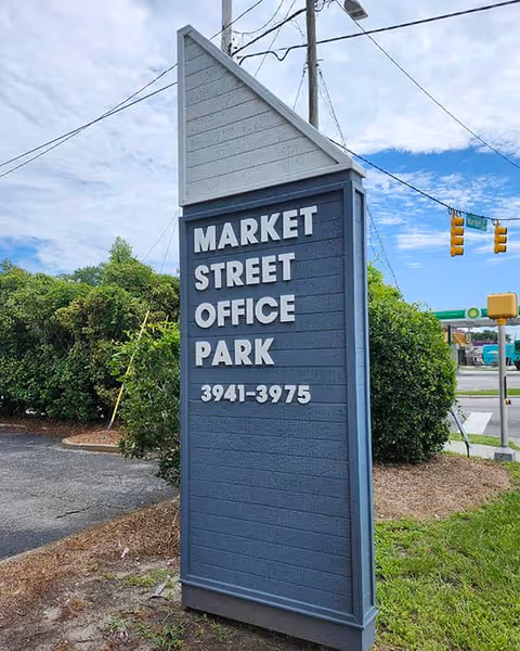 Blue exterior sign reading Market Street Office Park beside a roadway