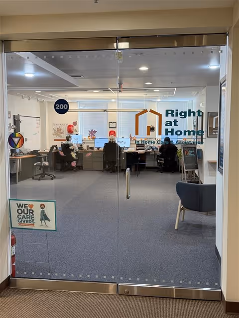 Glass doors reveal a Right at Home office with staff working at desks.