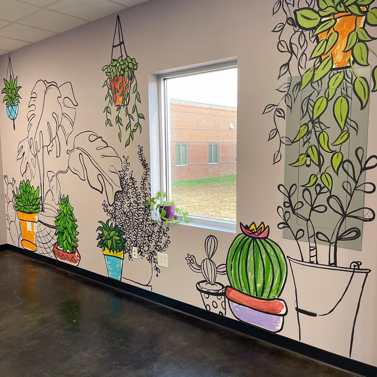 Interior wall mural of potted plants and vines beside a window in a senior facility.