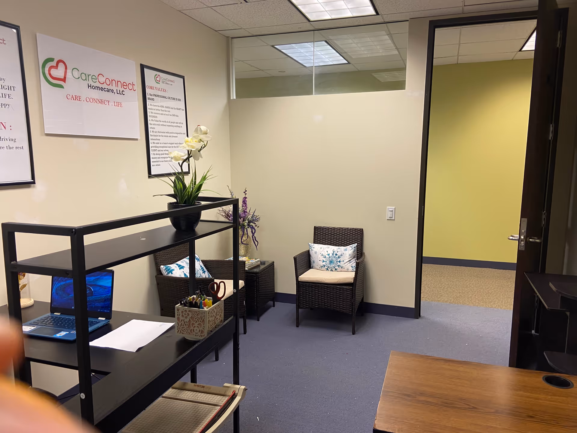 A small interior reception area with a desk, computer, and seating.