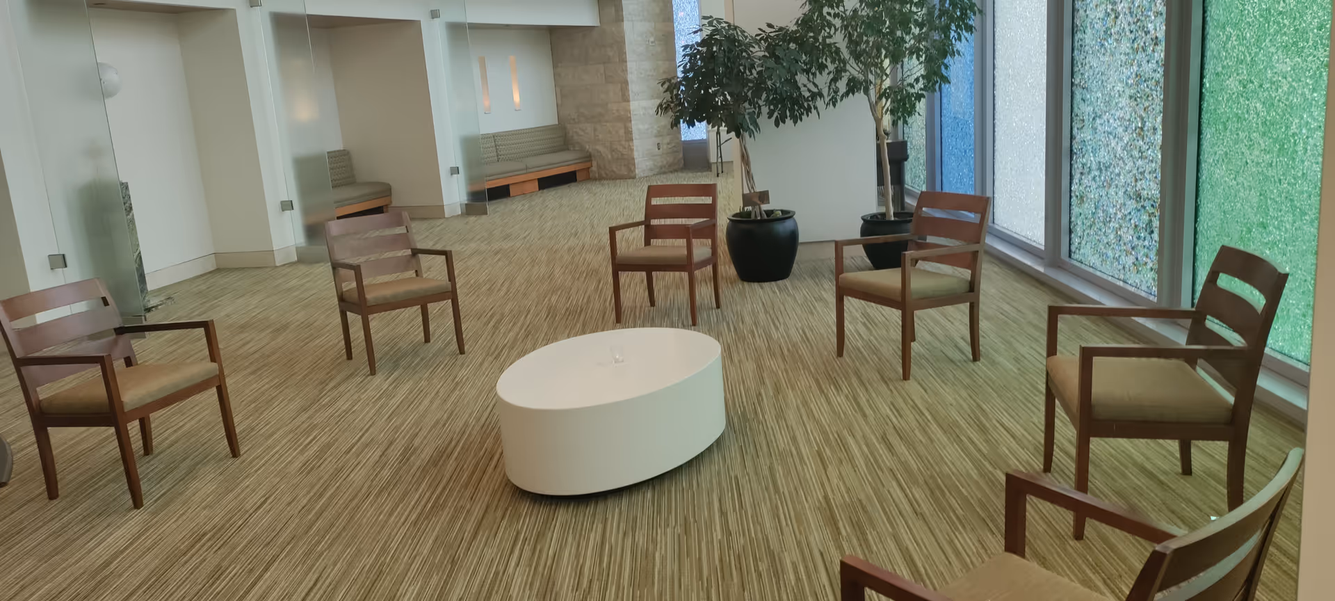 Interior lounge area with round white coffee table and wooden chairs arranged in a circle