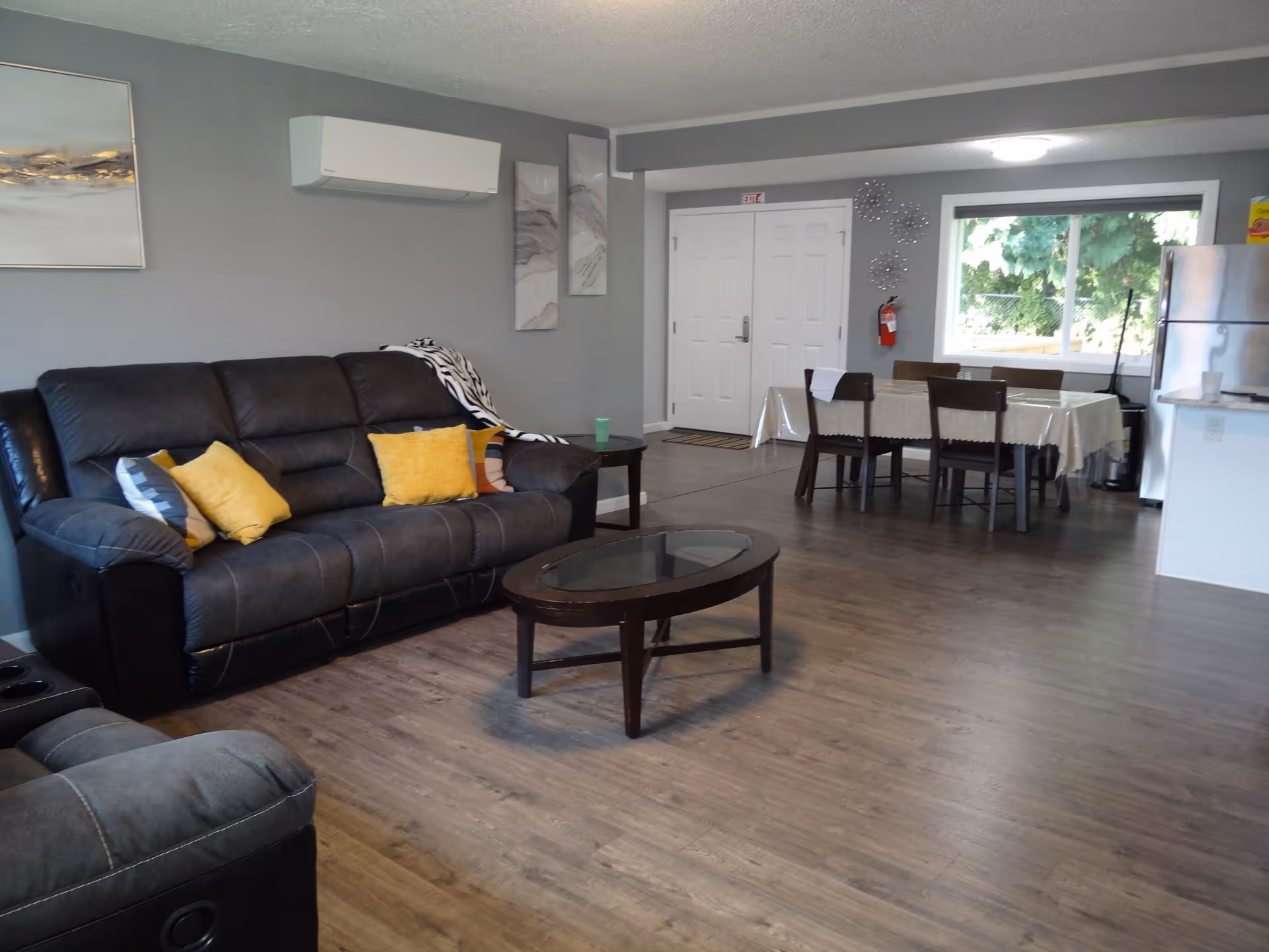 Spacious living area with sofa, coffee table, dining table, and kitchen visible.