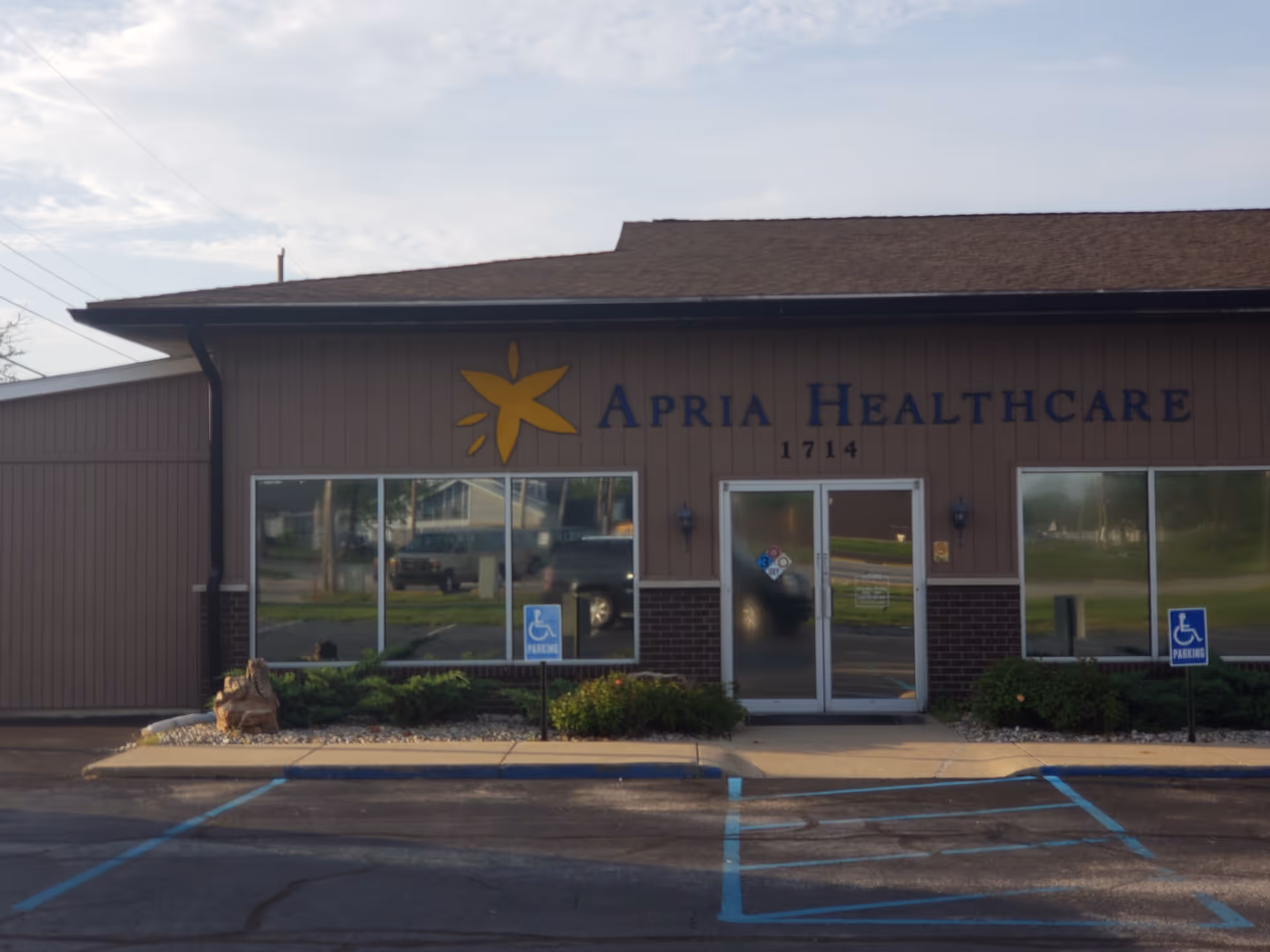 Exterior view of Apria Healthcare building with yellow flower logo and glass doors