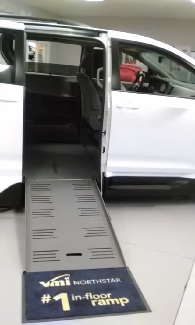 White MobilityWorks van with an extended in-floor ramp inside a showroom.