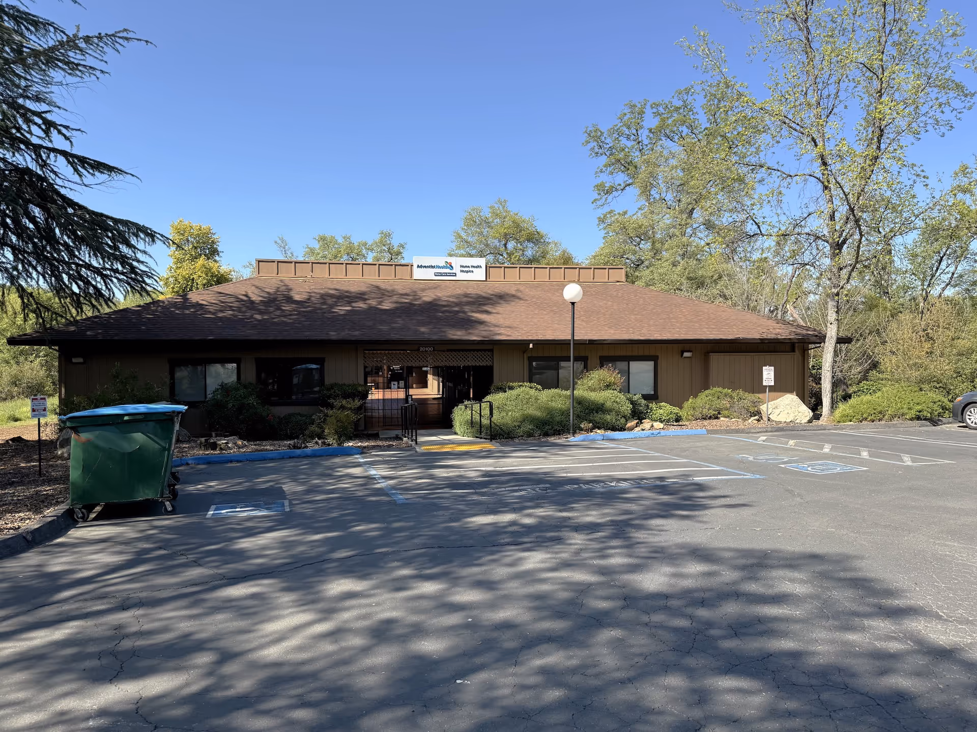 Front view of Adventist Health Home Care Services building with parking and trees.