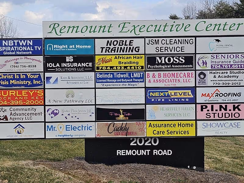 Exterior wall with a large multi-sign display including Right at Home logo