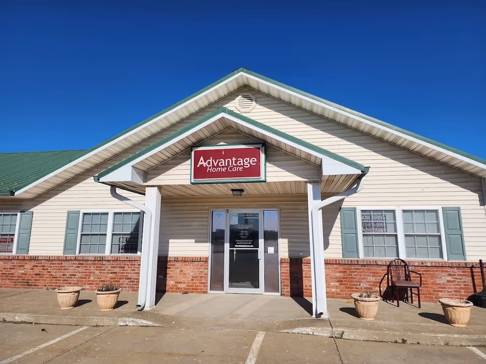 Front exterior of Advantage Home Care building with entrance and sign against blue sky.