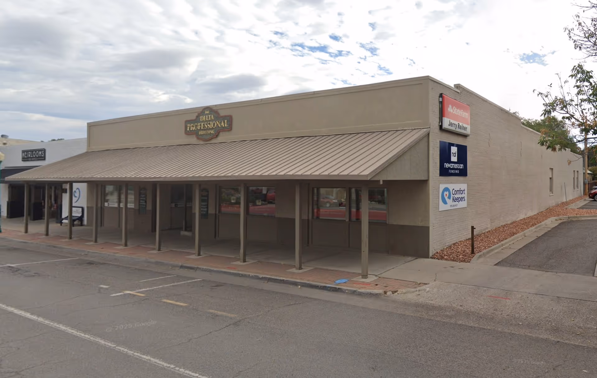 Single-story beige building with a long covered walkway and Comfort Keepers signs