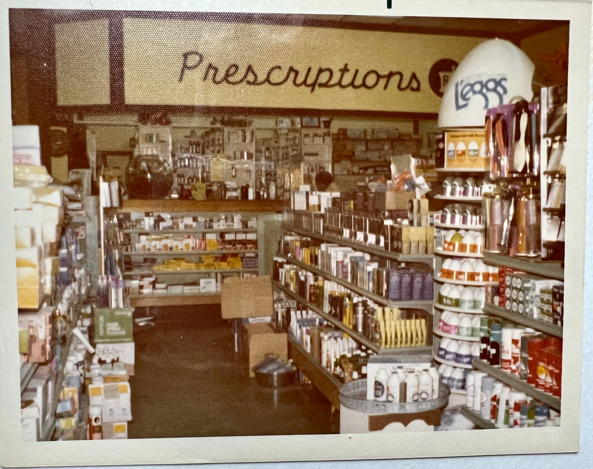 Interior view of Boone Drug and Healthcare at Deerfield pharmacy with shelves and prescription sign.