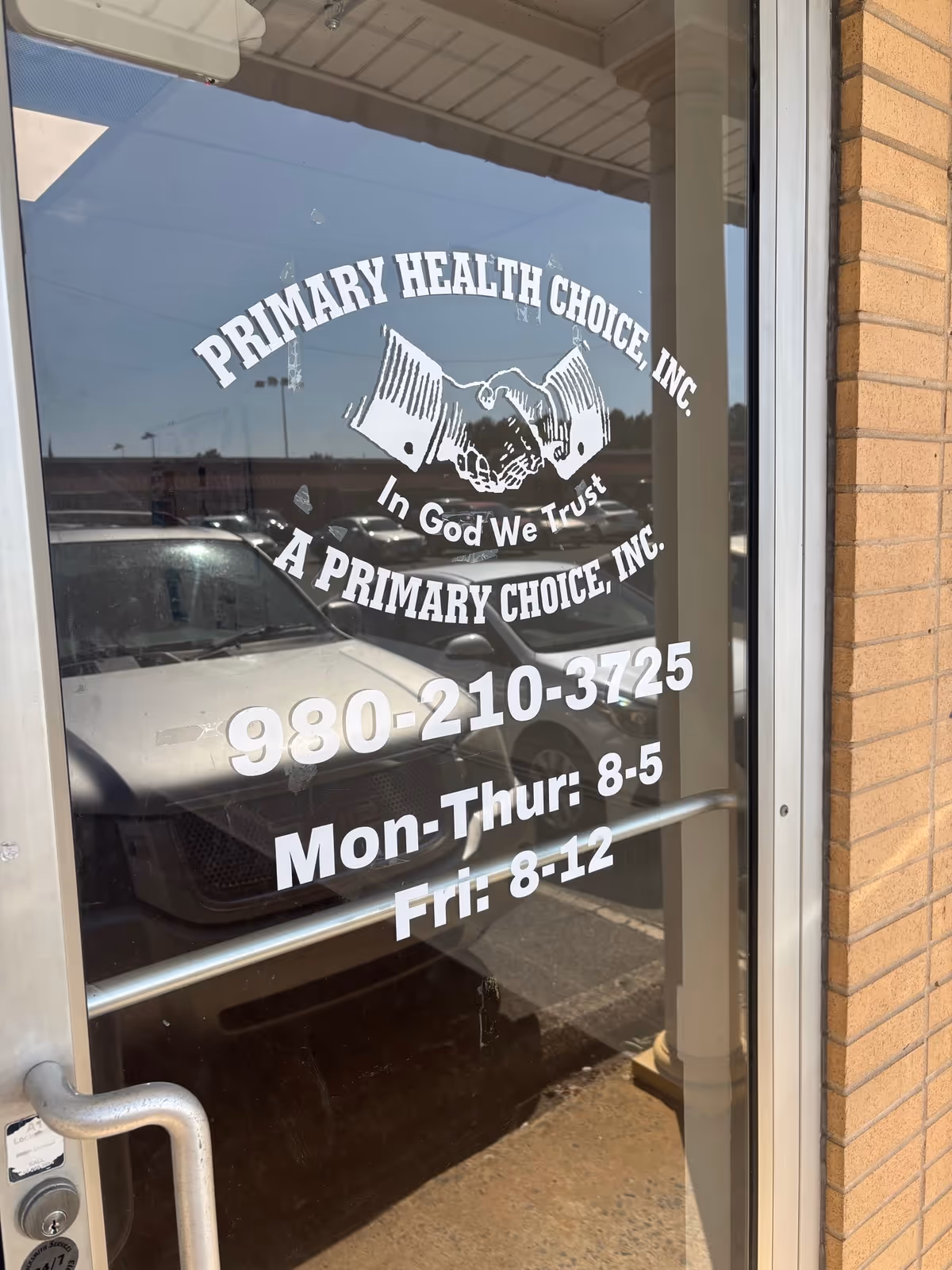 Glass entrance door displaying the facility's name, logo, and hours.